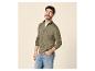 Mann in grüner Strickjacke mit Reißverschluss und blauen Jeans, lächelnd.
