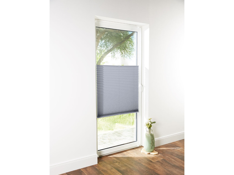 Ein grauer Plissee-Rollladen an einem Fenster