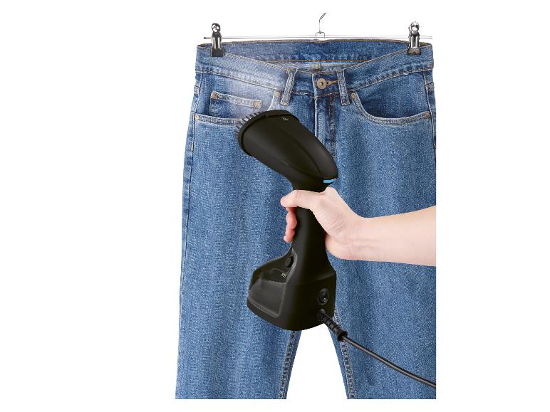 Ein Dampfbügeleisen wird zum Glätten einer Jeans verwendet.