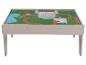 Spieltisch mit farbenfrohem Landschaftsthema, das einen See, Wege und Gebäude zeigt.