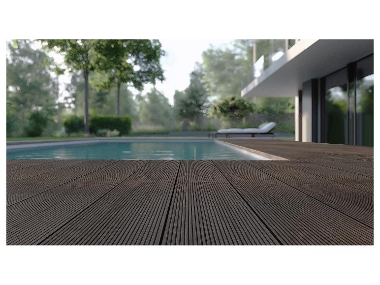 Holzterrasse am Pool mit modernem Haus und Grünflächen im Hintergrund.
