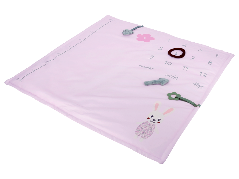 Rosa Babydecke mit Zahlen und Spielzeug.