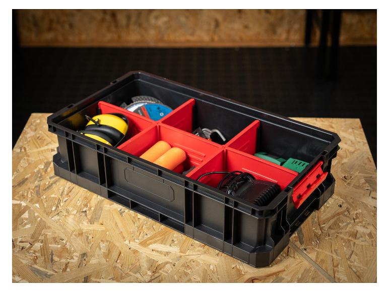 Schwarzer Werkzeugorganizer mit roten Trennwänden, gefüllt mit Arbeitsgeräten auf einer Holzplatte.