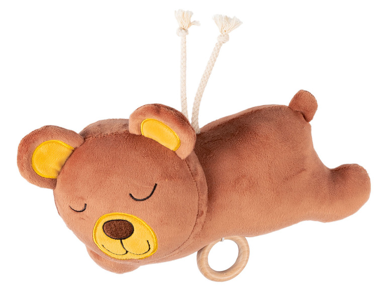 Ein brauner Stoffteddy mit einem Holzring und Schnüren.