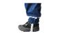 Nahaufnahme eines Kinderbeins in blauer wasserdichter Hose mit Reflexstreifen und grauem Schuh.