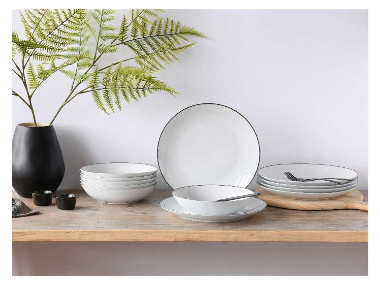 Weiße Schüsseln und Teller mit schwarzem Rand; elegantes Geschirr.