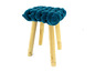 Ein blauer, geflochtener Hocker mit Holzbeinen.