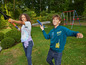 Zwei Kinder spielen im Freien mit einem Spielzeugflugzeug und einer Raketenwerfer.