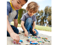 Zwei Jungen spielen draußen im Sand mit bunten Spielzeugautos.