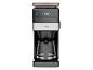 Kaffeemaschine mit Digitalanzeige 8:30, Glaskanne und orangefarbenen Akzenten.