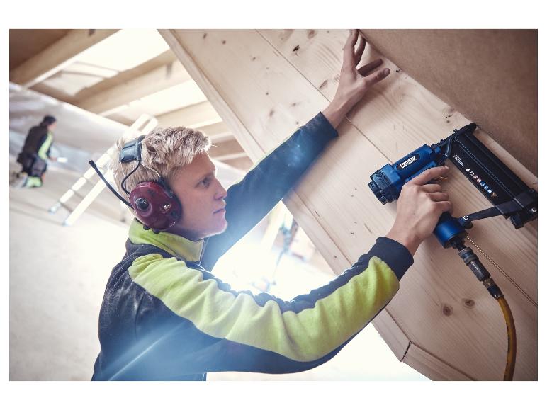 Mann befestigt Holzpaneele mit einem LIVARNO® Drucklufttacker/-nagler.