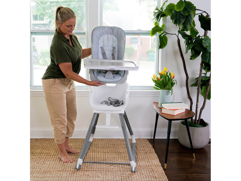 Eine Frau baut einen Ingenuity Hochstuhl zusammen