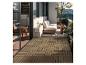 Balkon mit ineinandergreifenden Holzfliesen, Outdoor-Sofa und Pflanzen.