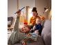 Mutter und Kinder spielen ein Brettspiel auf dem Sofa.