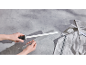 Hände schärfen ein Messer mit einem Keramik-Wetzstahl auf grauem Hintergrund mit einem Küchentuch.