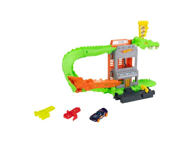 Spielzeugautobahn mit grünem Alligator, Gebäude und dunkelblauem Spielzeugauto.