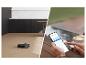 Saugroboter reinigt Holzboden, gesteuert über ein Smartphone.