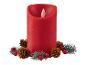 Eine rote LED-Kerze umgeben von Tannenzweigen und Zapfen.