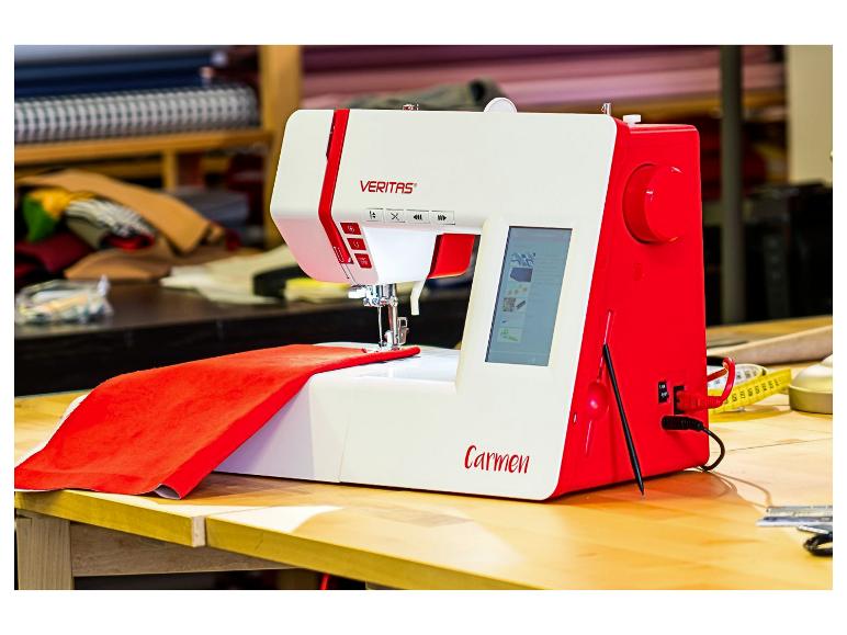 Rot-weiße Nähmaschine mit Stoff auf einem Holztisch in einer Werkstatt