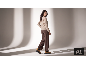 Frau in einem eleganten beigen Strickpullover, brauner Hose und Stiefeletten.