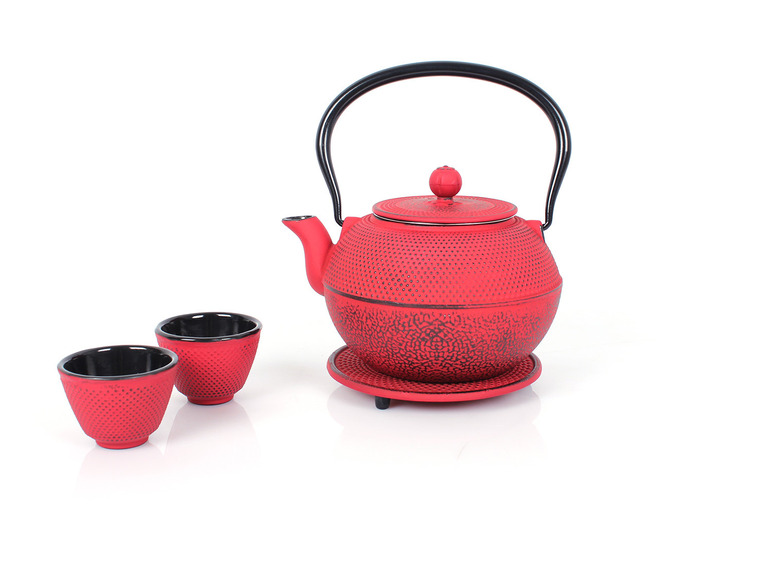 Ein roter gusseiserner Wasserkocher mit zwei Tassen