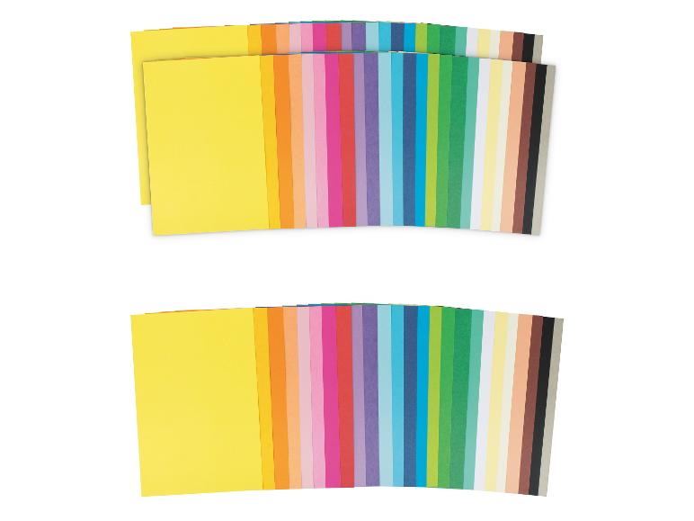 Zwei Stapel verschiedenfarbiges Papier, darunter Gelb, Orange, Pink, Blau und Grün.