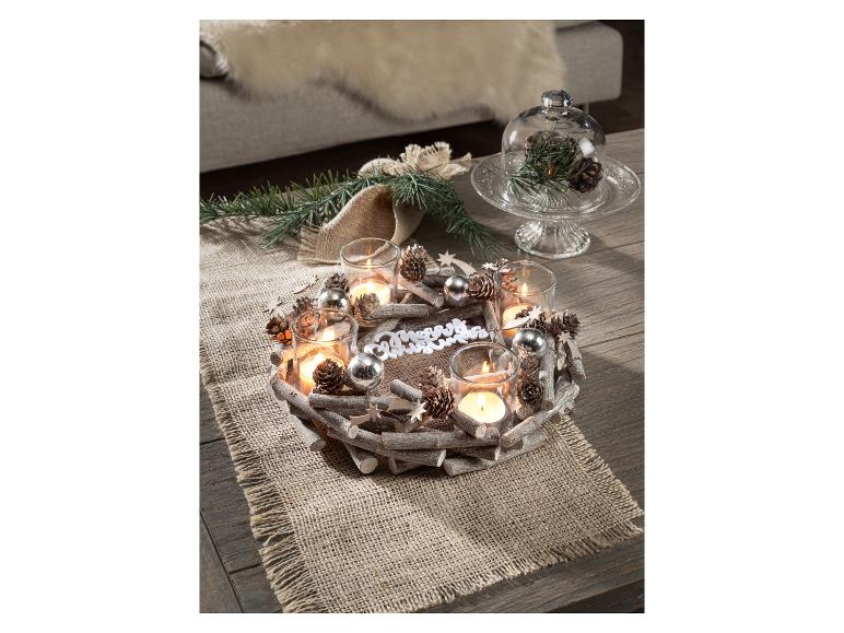Hölzerner Adventskranz mit Kerzen, Tannenzapfen und Weihnachtsdekorationen.