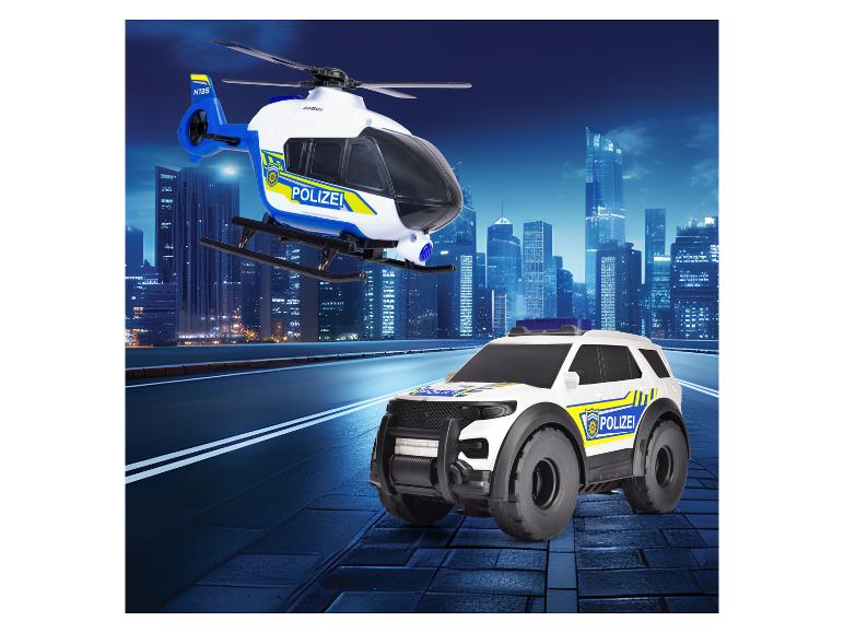 Polizeihubschrauber- und Polizeiauto-Spielzeuge vor einer Stadtskyline.