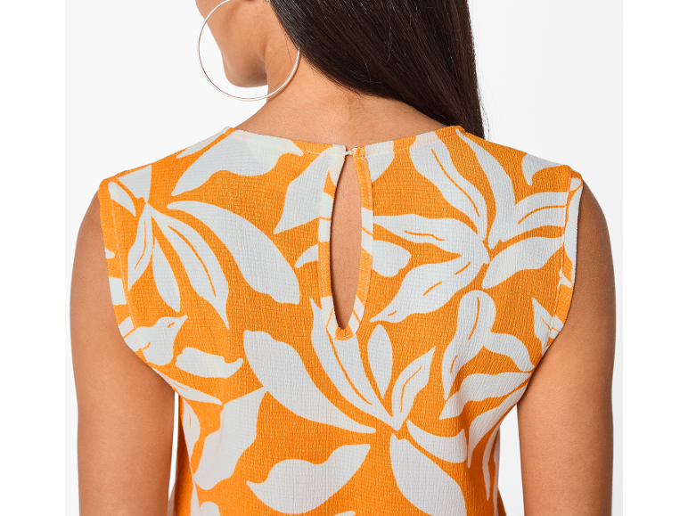 Rückenansicht einer Frau in einem orangefarbenen Top mit weißen Blumenmustern und Ausschnitt.