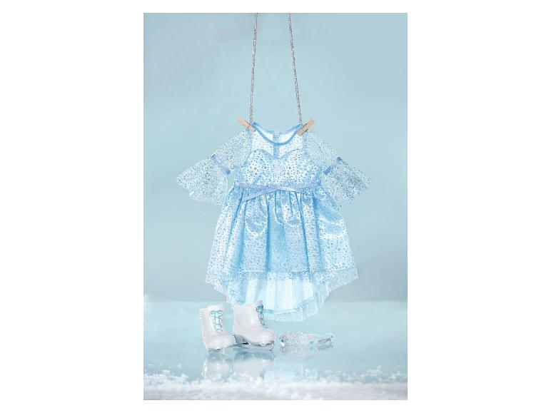 Blaues Glitzerkleid, weiße Schlittschuhe und Diadem für Puppen, hängend vor hellblauem Hintergrund.