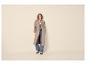 Frau in beigem Trenchcoat, gestreiftem Hemd, Jeans und zweifarbigen Loafern.