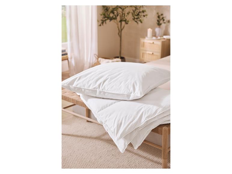 Weißes Kissen und Bettdecke auf einer Holzbank in einem gemütlichen Schlafzimmer.