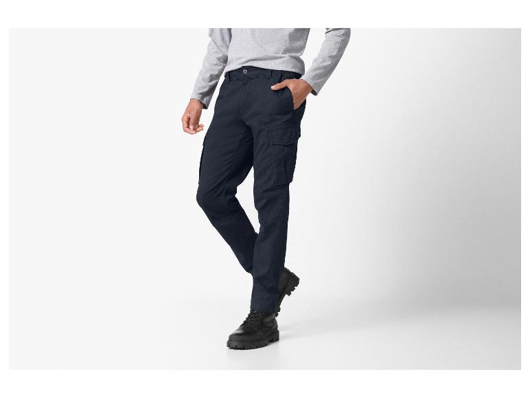 Mann in dunkelblauer Cargohose und grauem Langarmshirt