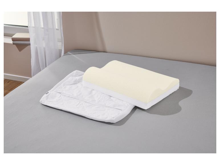 Ein Memory-Schaum-Kissen und sein Kissenbezug liegen auf einem Bett.