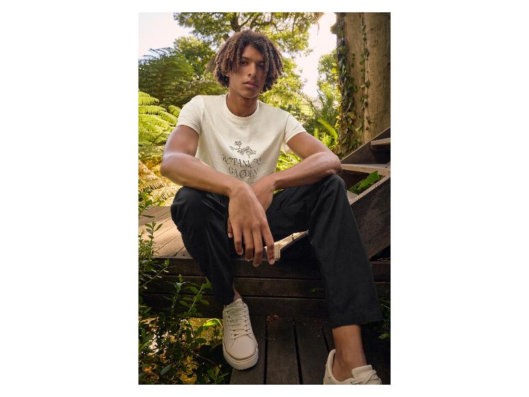 T-Shirt und Sneakers: lässiger Look in einem botanischen Garten.