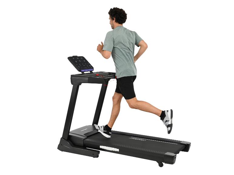 Mann läuft auf einem schwarzen Laufband.