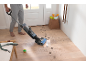 Ein Mann reinigt einen Holzboden mit einem kabellosen Hartbodenreiniger.