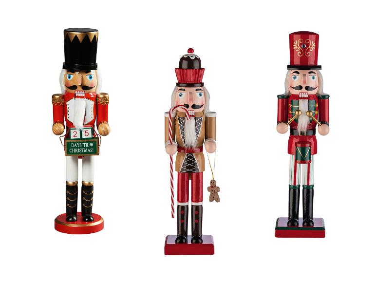 Drei hölzerne Nussknacker, einer mit einem Countdown-Kalender, einer mit einem Zuckerstange und Lebkuchenmann, und der letzte mit einer Trommel.