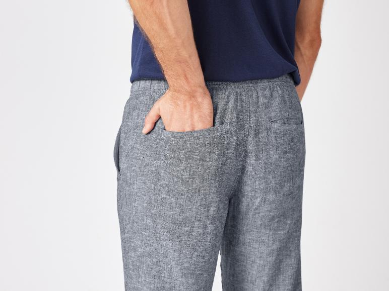 Graue Leinenhose und dunkelblaues T-Shirt.