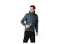 Mann in einer wattierten Kapuzenjacke und schwarzer Hose, hält eine Metallflasche.