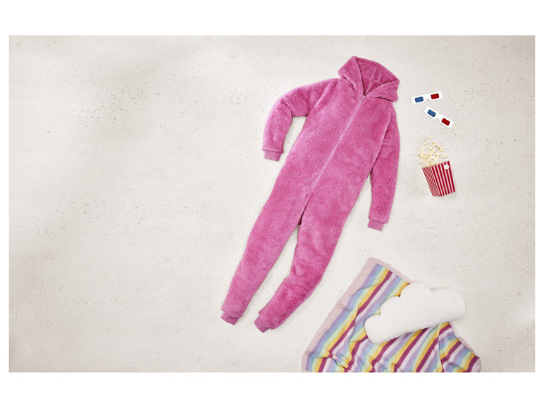 Ein rosafarbener Schlafanzug, Popcorn, 3D-Brille und eine gestreifte Decke.
