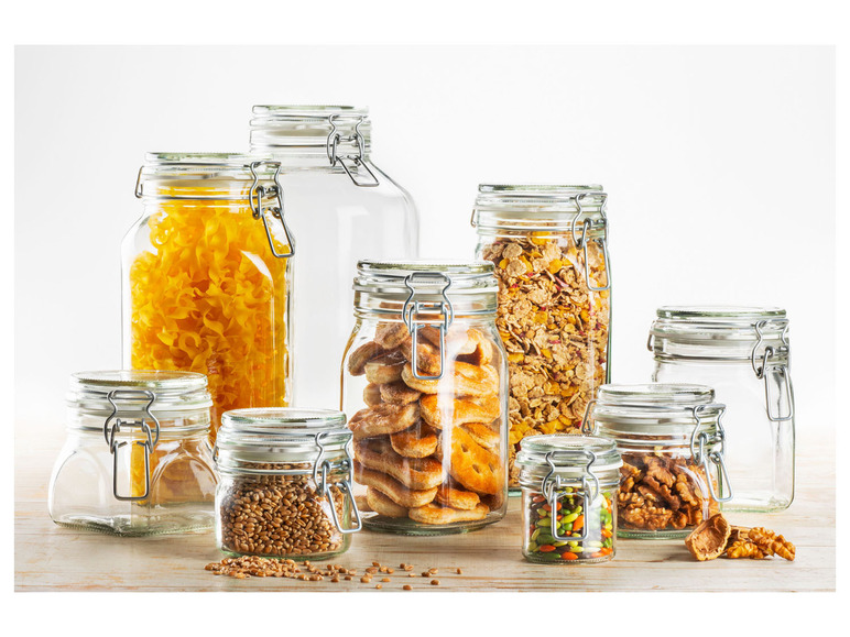 Glasbehälter mit Pasta, Müsli, Keksen, Getreide und Nüssen.