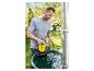 Mann setzt eine gelbe Pumpe in eine Regentonne im Garten.