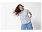 Lächelnde Frau in blauem Hemd und Jeans