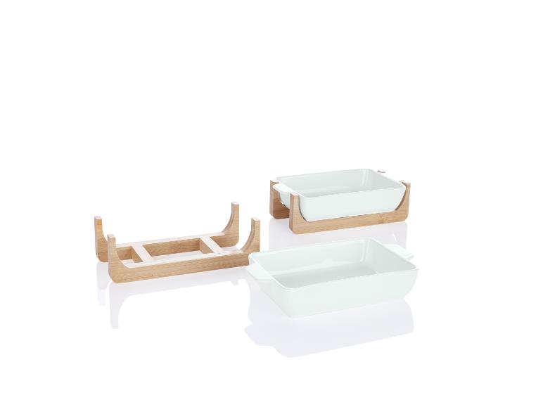 Zwei weiße Keramik-Backformen auf einem Bambusständer.