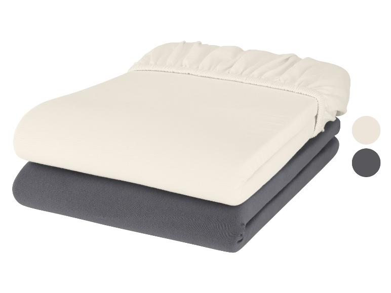 Zwei Spannbettlaken: ein cremefarbenes und ein dunkelgraues