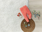 Rosa Babyhose, Holzrassel und geflochtene Matte.