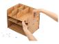 Person montiert einen hellen Holz-Schreibtisch-Organizer mit mehreren Fächern.