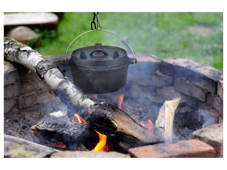 GSW Dutch Oven hängt über einem Lagerfeuer, mit Flammen und Rauch sichtbar.