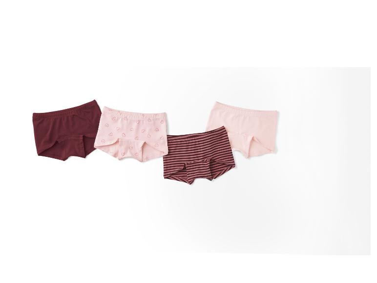 Vier Paar Mädchenunterhosen in verschiedenen Farben und Mustern.